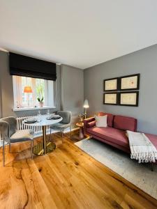 uma sala de estar com um sofá vermelho e uma mesa em Premium Apartment an der Stadtmauer im OG em Paderborn