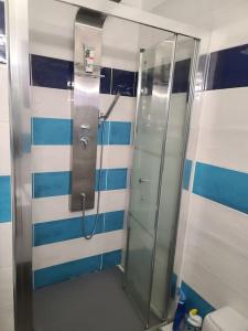 baño con cabina de ducha de rayas azules y blancas en Plages 130 m, parking privé, climatisé, wifi/fibre, en Valras-Plage