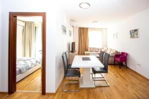 Zimmer mit einem Tisch und Stühlen sowie einem Schlafzimmer in der Unterkunft Apartmans Budva centar in Budva
