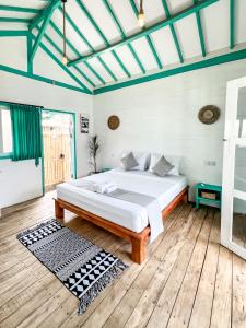 a bedroom with a bed and a wooden floor at Casa Kapuas in Gili Trawangan