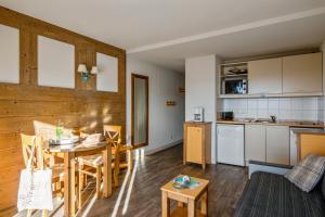a kitchen and living room with a table and chairs at Résidence Pierre & Vacances Le Pédrou in Font-Romeu