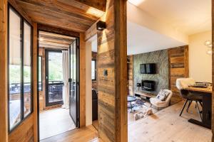 un salon avec des murs en bois et une chambre avec un bureau dans l'établissement Le Bouquetin - IMMODREAMS - Avoriaz, à Avoriaz