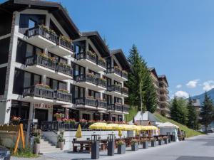ein Gebäude mit gelben Sonnenschirmen davor in der Unterkunft Hôtel Cristal - Swiss Riders Lodge Grimentz in Grimentz