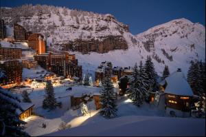 a town in the snow at night with a mountain at Le Sosna - IMMODREAMS - Avoriaz in Avoriaz