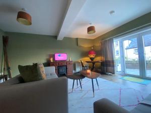 a living room with a couch and a tv at Old Boathouse Upper Lough Erne in Fairfield