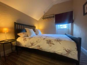 a bedroom with a bed and a lamp and a window at Old Boathouse Upper Lough Erne in Fairfield