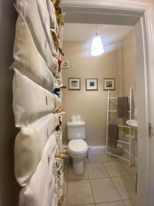 a bathroom with a toilet and a wall of towels at Old Boathouse Upper Lough Erne in Fairfield +26 photos