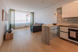 a kitchen and living room with a couch and a table at SKAU Sky Park Coral by Zaha Hadid 22 floor 1Tower Panoramic View Free Parking in Bratislava