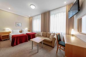 um quarto de hotel com uma cama e um sofá em Rixwell Viru Square Hotel em Talin