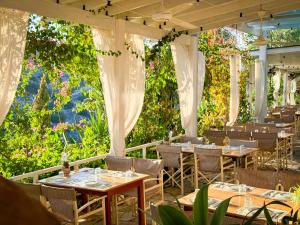 a restaurant with tables and chairs and flowers at Cyprus Villages Hotel & Restaurant - Central Location - Bed & Breakfast - With Access To Pool And Stunning Views in Tochni