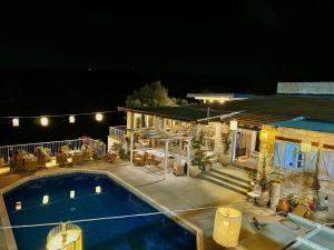 a swimming pool in front of a house at night at Cyprus Villages Hotel & Restaurant - Central Location - Bed & Breakfast - With Access To Pool And Stunning Views in Tochni