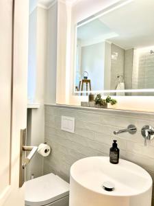 W łazience znajduje się biała umywalka i lustro. w obiekcie Premium Apartment an der Stadtmauer im OG w mieście Paderborn