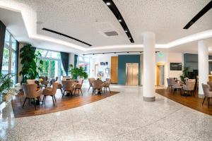 a lobby with tables and chairs in a building at Andante Hotel Dresden in Dresden