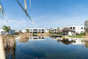 a view of a lake in front of buildings at Appartements Thermen-Golfresort Pannonia in Zsira