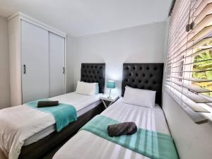 - une chambre avec 2 lits et une fenêtre dans l'établissement 58 Chakas Cove - Perfect Beachside Family Holiday, à Ballito
