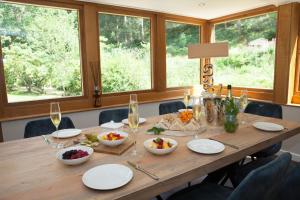 uma mesa de madeira com taças de comida e taças de vinho em Marrington Mill - Marrington Escapes em Chirbury