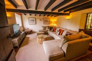 uma sala de estar com um sofá e uma televisão em Marrington Mill - Marrington Escapes em Chirbury