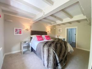 um quarto com uma cama grande e almofadas cor-de-rosa em Marrington Mill - Marrington Escapes em Chirbury