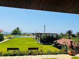 einen Park mit Bänken und einem Pool im Hintergrund in der Unterkunft Resort Terra Paraiso in Calangute