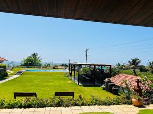 a park with benches and a pool in the background at Resort Terra Paraiso in Calangute