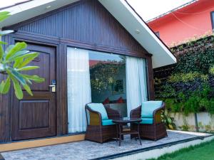 d'une terrasse avec 2 chaises et une table à côté d'une porte. dans l'établissement Resort Terra Paraiso, à Calangute