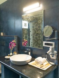 a bathroom with a sink and a large mirror at Resort Terra Paraiso in Calangute