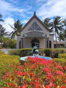 a building with a statue in a garden with flowers at Le Choisy Mauritius in Mont Choisy