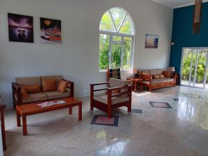 a living room with couches and chairs and a window at Le Choisy Mauritius in Mont Choisy