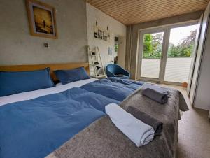 a bedroom with a large bed with blue sheets at Casa Azul in Flensburg