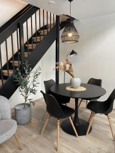 a dining room with a black table and chairs at Brand new loft apartment with glazed balcony in Tampere