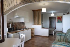 eine offene Küche und ein Wohnzimmer mit einem Tisch und Stühlen in der Unterkunft B&B Le Colline Country House in Anguillara Sabazia