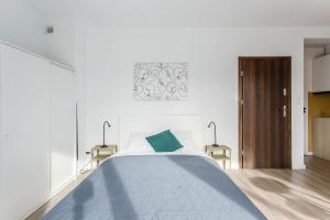 a bedroom with a large bed with a blue blanket at Chill Apartments Warszawa Piaseczno in Józefosław