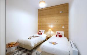 - une chambre avec deux lits et une table avec une lampe dans l'établissement Résidence Sorbier by Leavetown Vacations, à Les Deux Alpes