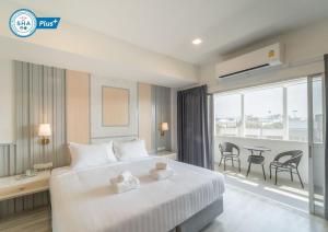 a hotel room with a large bed and a balcony at The Space Hotel Lampang in Lampang