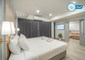 1 dormitorio con cama blanca y sofá en The Space Hotel Lampang en Lampang