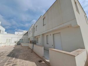 a large white building with a parking lot at Villette smile s m di leuca in Leuca