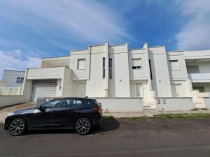 a black car parked in front of a house at Villette smile s m di leuca in Leuca