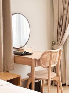 a bedroom with a desk with a mirror and a chair at SO Zen Hotel Silom Bangkok in Bang Rak