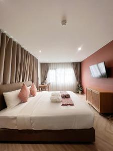 SO Zen Hotel Silom Bangkok في بانغ راك: غرفة نوم مع سرير أبيض كبير مع جدران وردية