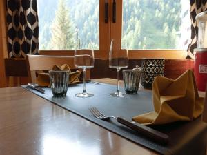 una mesa con copas de vino y una servilleta. en Hôtel Cristal - Swiss Riders Lodge Grimentz, en Grimentz