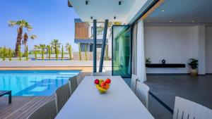 a table with fruit on it next to a swimming pool at Sunrise Beachfront Villas - Villa 1 in Paralimni