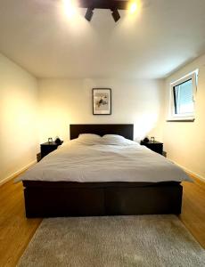 um quarto com uma cama grande e 2 mesas de cabeceira em Central Apartment / BBQ Terrace / Big NetflixTV em Bayreuth