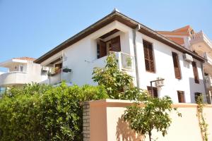 a white house with trees in front of it at Apartments Kaludjerovic in Herceg-Novi