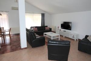 a living room with black leather furniture and a flat screen tv at Apartman Debora sa privatnim bazenom in Pula