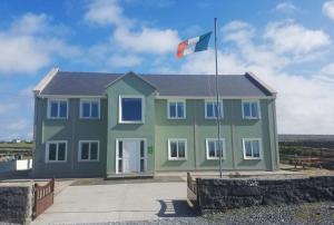 een groen huis met een vlag erop bij Aran Walkers Lodge in Inis Mor