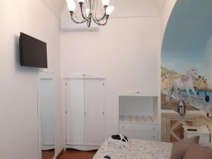 Habitación blanca con cama y TV en la pared en ApartHotel Antica Repubblica in Amalfi center at 100mt from the sea with payment parking, en Amalfi