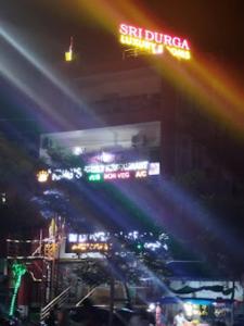 una città illuminata di notte con un edificio di Sri Durga Luxury A/C Rooms,Sircilla a Sirsilla