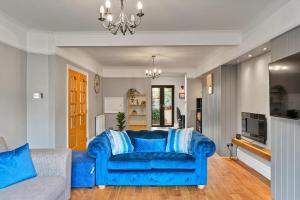 a living room with a blue couch and a television at Finest Retreats - The Lookout in Ilfracombe