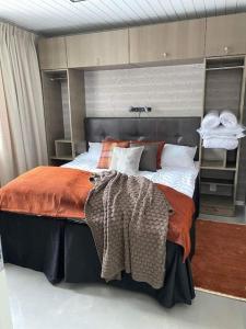 a bedroom with a large bed with an orange blanket at Fantastisk Stuga i Hälsingland, Los! in Los