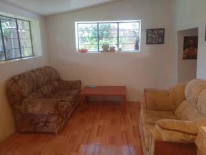 a living room with two couches and a table at Casa de campo hospedaje RyM in Sicuani